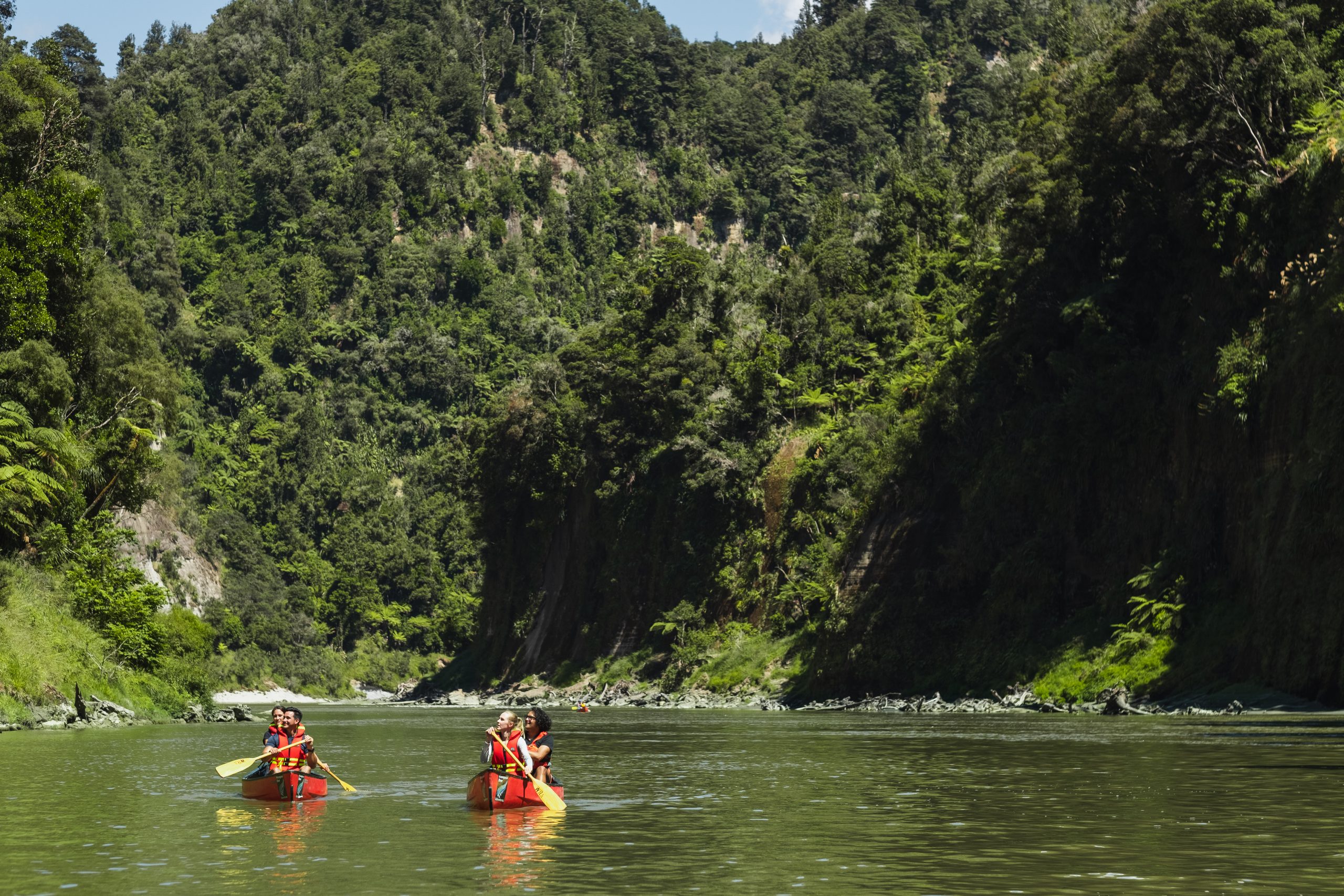 People in two canoes paddling down the Whanganui River